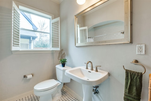 bathroom featuring a shower with shower curtain, baseboards, and toilet