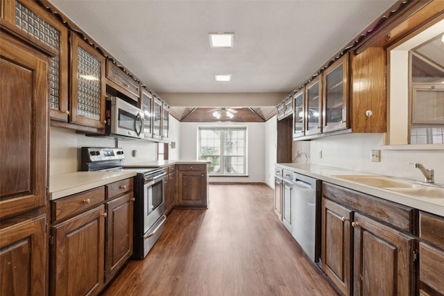 1878 Trail Ridge Dr, Lewisville, TX 75077 - kitchen featuring stainless steel appliances, a sink, dark wood-style flooring, glass insert cabinets, and light countertops