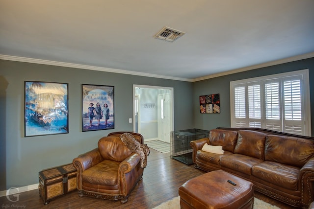 living area with visible vents, crown molding, and wood finished floors