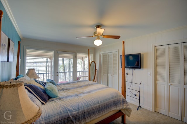 bedroom with light colored carpet, a ceiling fan, access to exterior, ornamental molding, and two closets