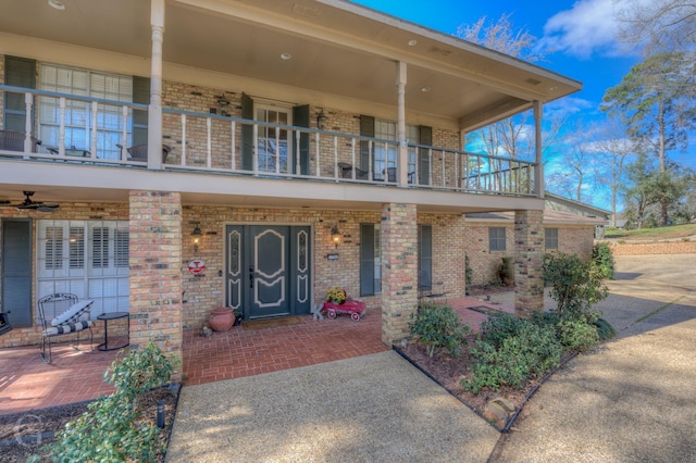 view of front facade featuring brick siding and a balcony