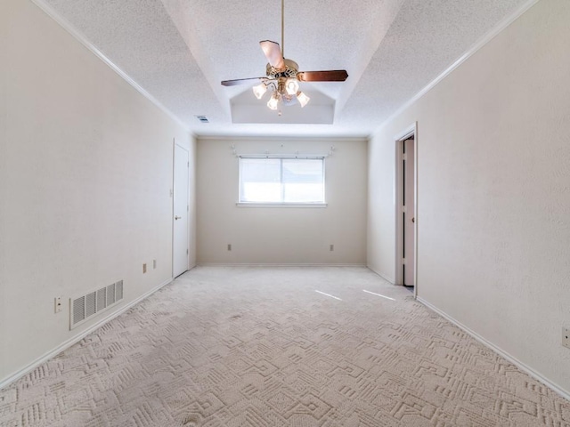 spare room featuring a tray ceiling, visible vents, a textured ceiling, and carpet