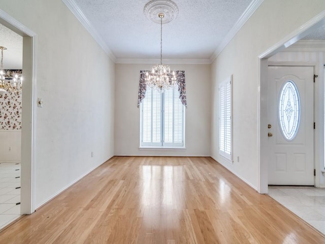 foyer featuring crown molding, a chandelier, a textured ceiling, and wood finished floors