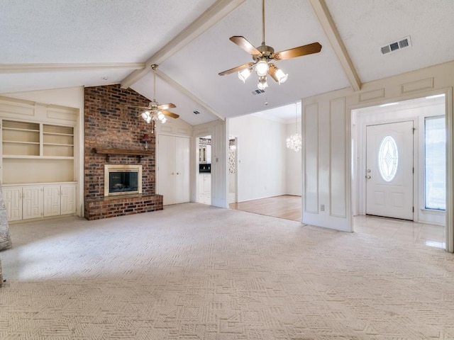 unfurnished living room featuring light carpet, lofted ceiling with beams, a textured ceiling, and a fireplace