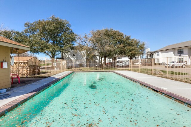 view of swimming pool with a residential view and fence