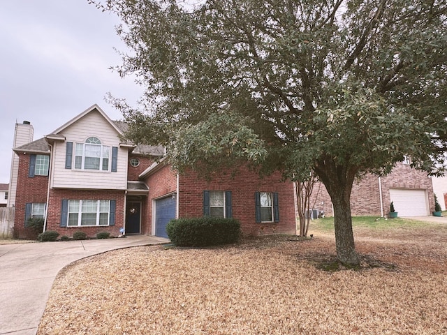 view of front of property featuring a garage, driveway, brick siding, and a chimney