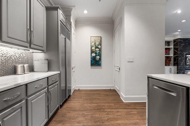 kitchen with dark wood-type flooring, gray cabinets, crown molding, and decorative backsplash