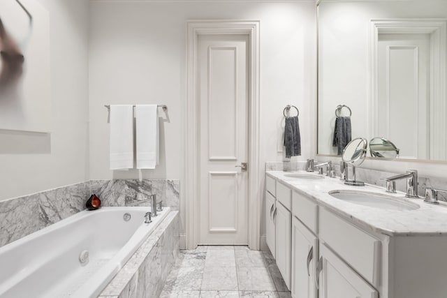 bathroom with double vanity, a garden tub, marble finish floor, and a sink