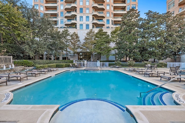 pool with a patio area and fence