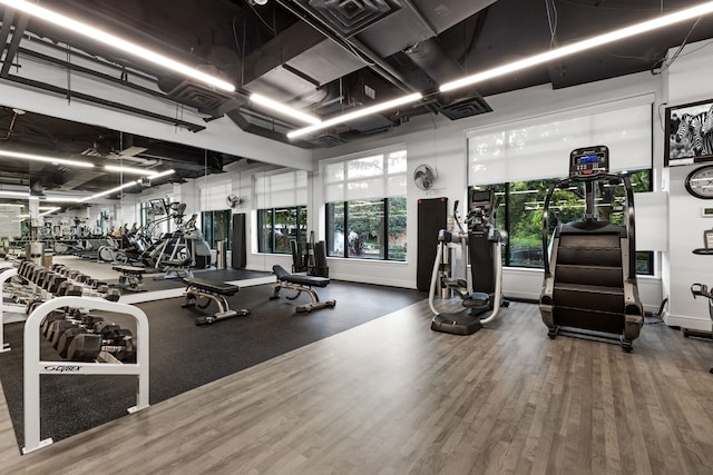 gym with wood finished floors, visible vents, and baseboards