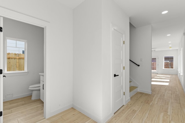 hallway with light wood-style floors, recessed lighting, stairway, and baseboards