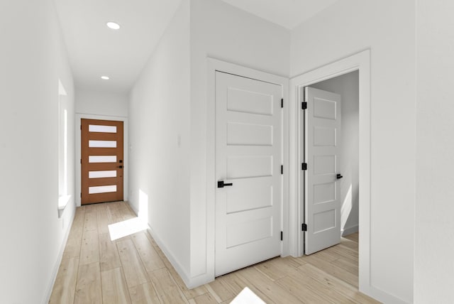 corridor with recessed lighting, light wood-type flooring, and baseboards