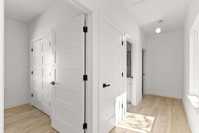 hallway featuring light wood-style floors and baseboards