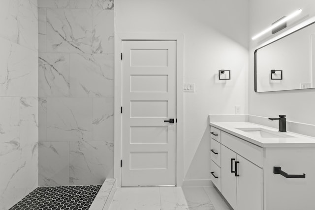 bathroom featuring marble finish floor, baseboards, vanity, and a marble finish shower