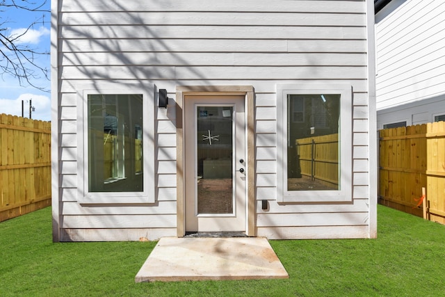 property entrance with a yard and fence