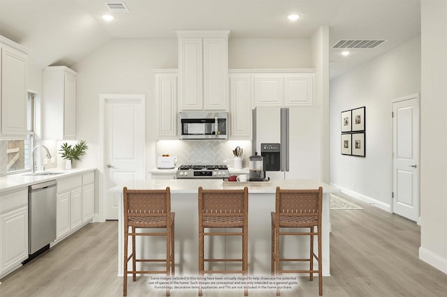 119 Emperor Oak Ct, Balch Springs, TX 75181 - kitchen featuring appliances with stainless steel finishes, a sink, decorative backsplash, light wood-style flooring, and white cabinetry