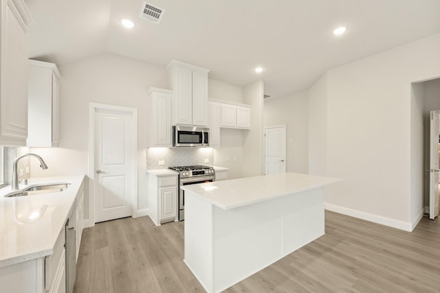 119 Emperor Oak Ct, Balch Springs, TX 75181 - kitchen featuring stainless steel appliances, a sink, backsplash, white cabinets, and light wood finished floors