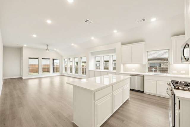119 Emperor Oak Ct, Balch Springs, TX 75181 - kitchen featuring stainless steel appliances, a sink, tasteful backsplash, a kitchen island, and light countertops