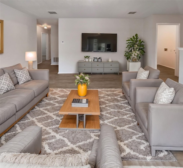 living area featuring wood finished floors and visible vents