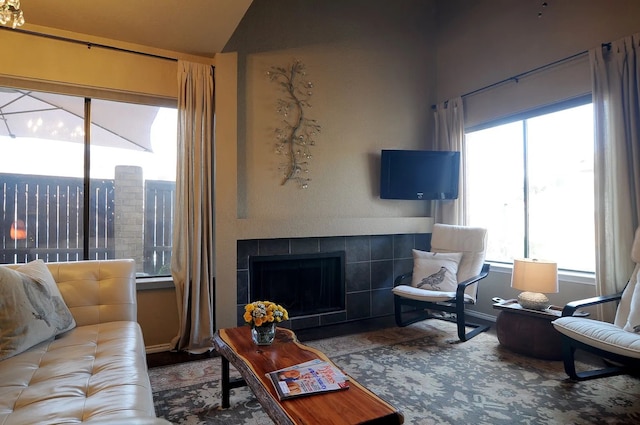 living room featuring vaulted ceiling and a tile fireplace