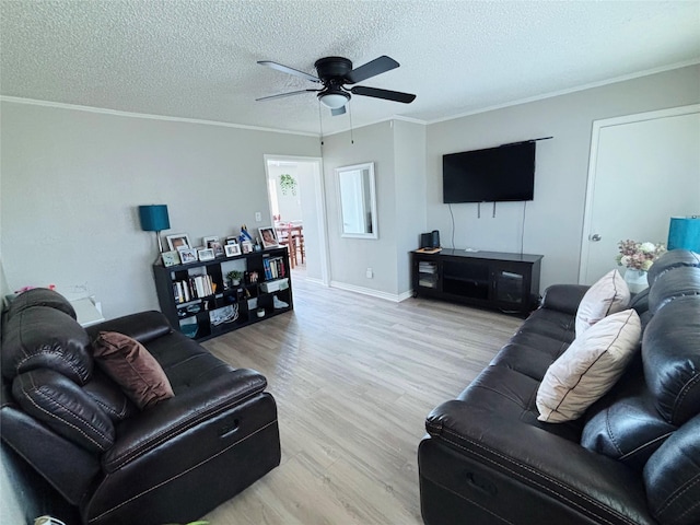 living room with light wood-style floors, ornamental molding, and a textured ceiling