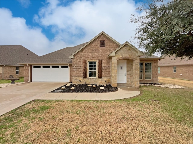 view of front of house with driveway, stone siding, an attached garage, a front lawn, and brick siding