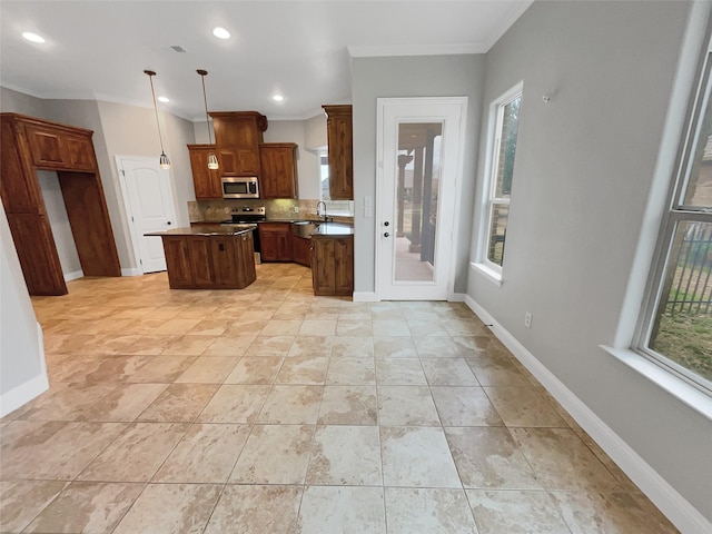 kitchen with appliances with stainless steel finishes, a sink, baseboards, and a kitchen island