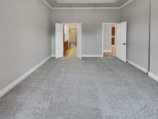 unfurnished bedroom with carpet, baseboards, ensuite bathroom, and ornamental molding