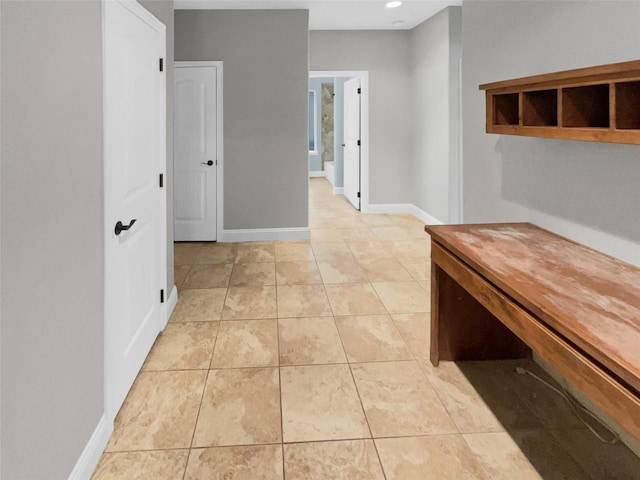 corridor featuring recessed lighting, light tile patterned flooring, and baseboards