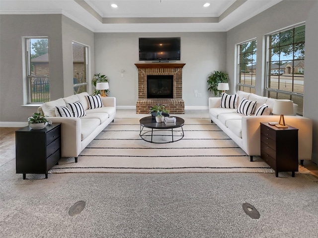 carpeted living room with a healthy amount of sunlight, baseboards, and ornamental molding