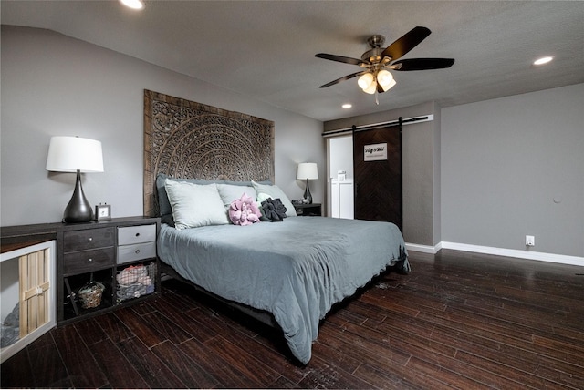 bedroom with a barn door, baseboards, wood finished floors, and recessed lighting