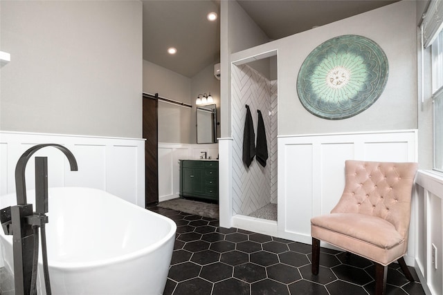 full bath with a wainscoted wall, a soaking tub, tile patterned flooring, vanity, and recessed lighting