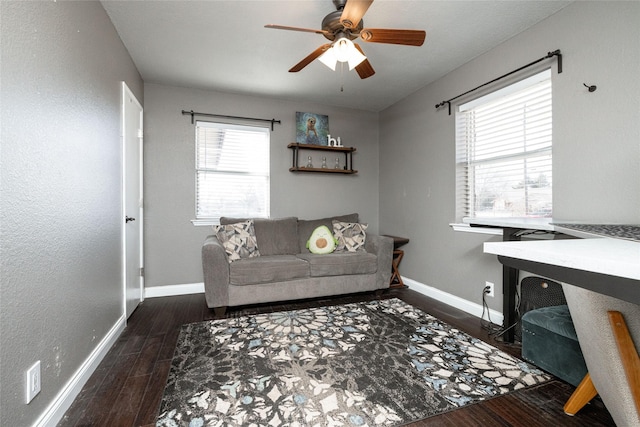 living area featuring ceiling fan, baseboards, and wood finished floors