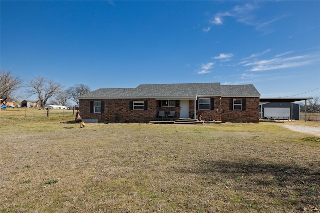 ranch-style home featuring brick siding, a porch, a carport, and a front yard