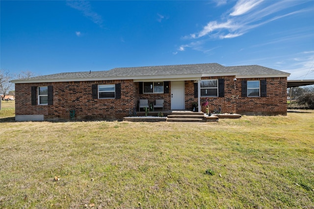 ranch-style house featuring roof with shingles, a front lawn, and brick siding