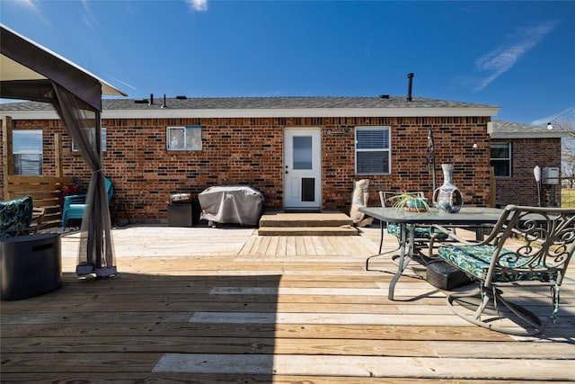 deck featuring outdoor dining area and grilling area