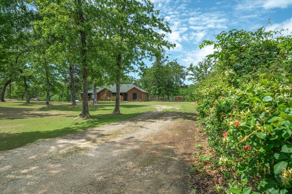 2766 Vz County Road 3104, Edgewood, TX 75117 - view of front of house with a chimney, driveway, covered porch, an outbuilding, and a garage