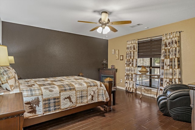 bedroom with baseboards, visible vents, and wood finished floors