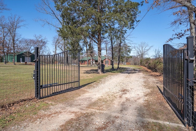 exterior space featuring a gate, dirt driveway, and a gated entry