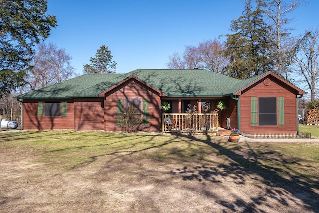 chalet / cabin with roof with shingles and a front yard