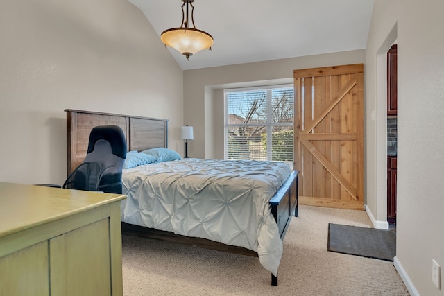 bedroom featuring light carpet, a barn door, baseboards, and vaulted ceiling