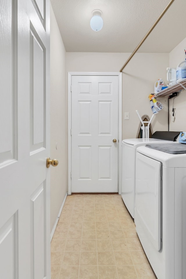 clothes washing area with laundry area, light tile patterned floors, baseboards, independent washer and dryer, and a textured ceiling