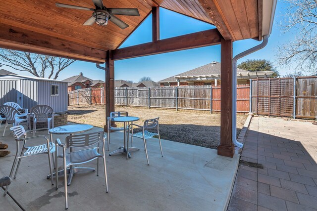 view of patio with ceiling fan, a fenced backyard, and outdoor dining area