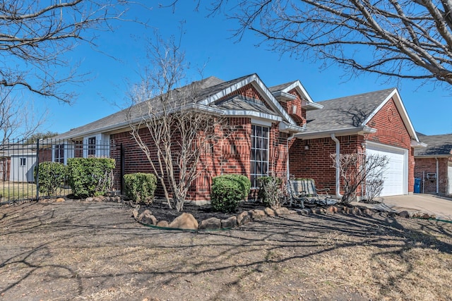 view of front of property with brick siding, roof with shingles, an attached garage, fence, and driveway