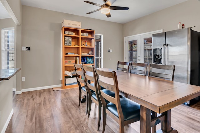 dining room featuring french doors, wood finished floors, a ceiling fan, and baseboards