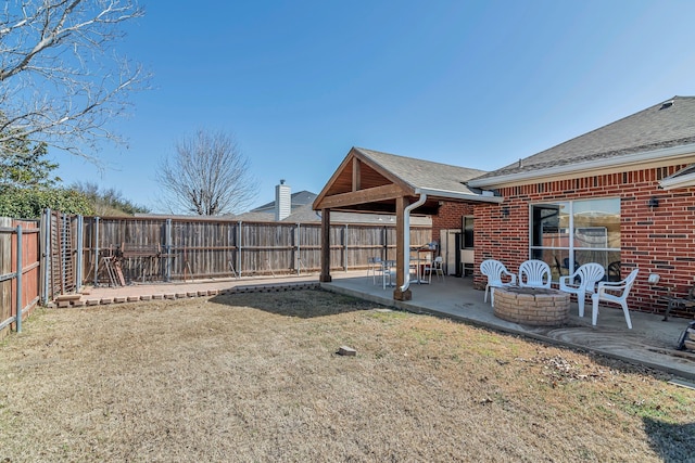 view of yard featuring an outdoor fire pit, a fenced backyard, and a patio