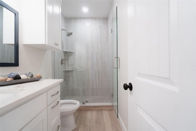 bathroom with toilet, a shower stall, and vanity