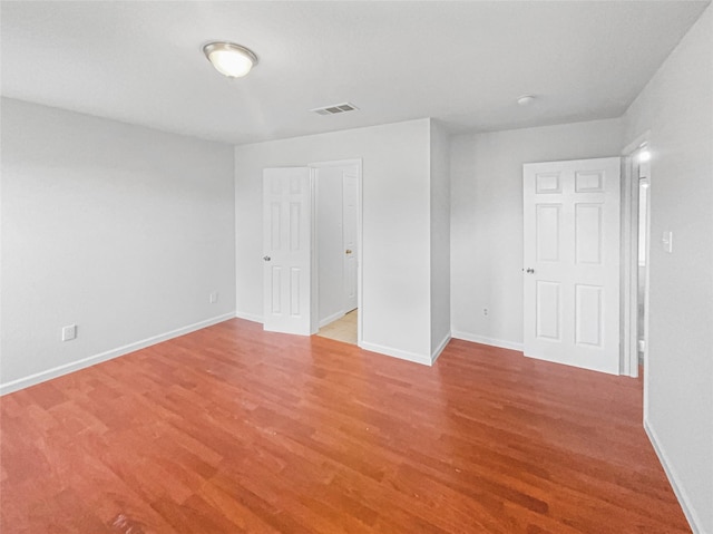 unfurnished bedroom with light wood finished floors, visible vents, and baseboards
