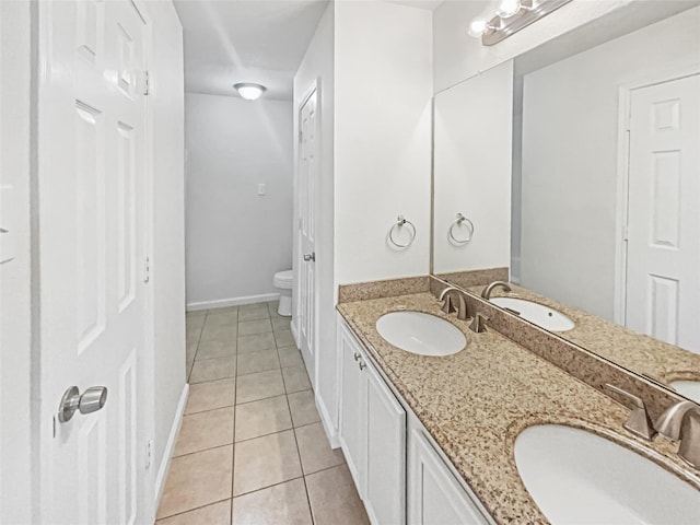 full bath with a sink, toilet, and tile patterned floors