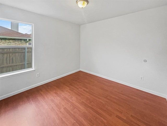 unfurnished room with wood finished floors and baseboards
